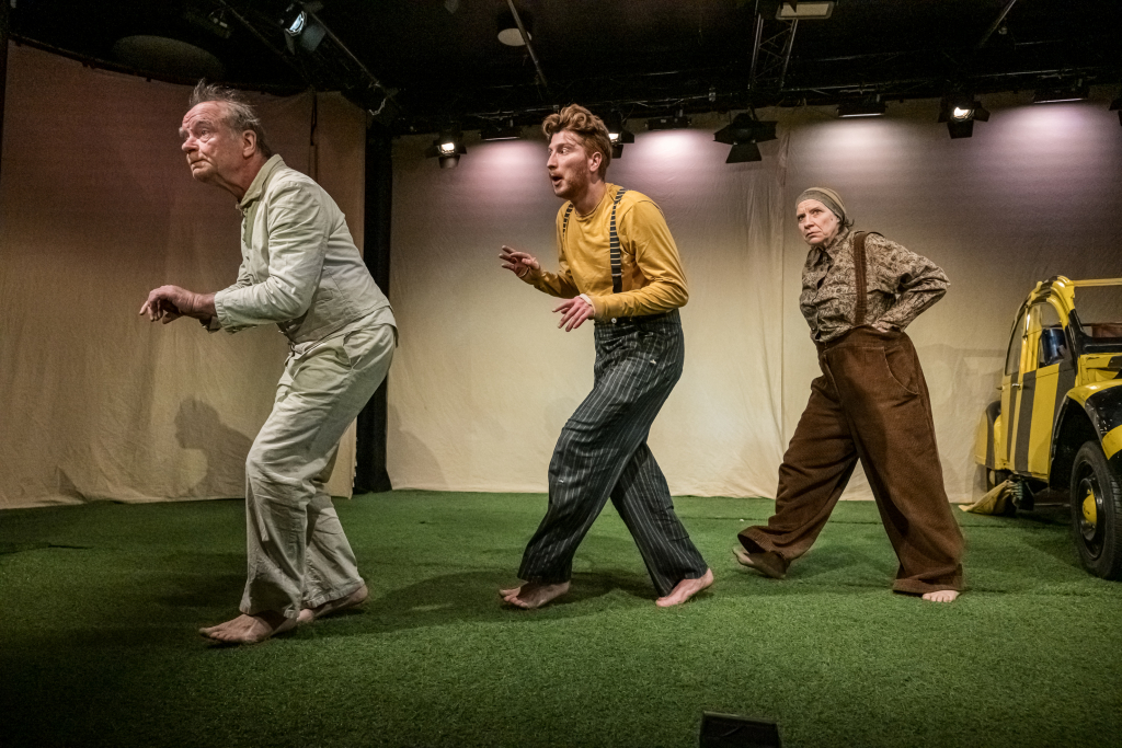 Drei Schauspieler*innen schleichen hintereinander her.