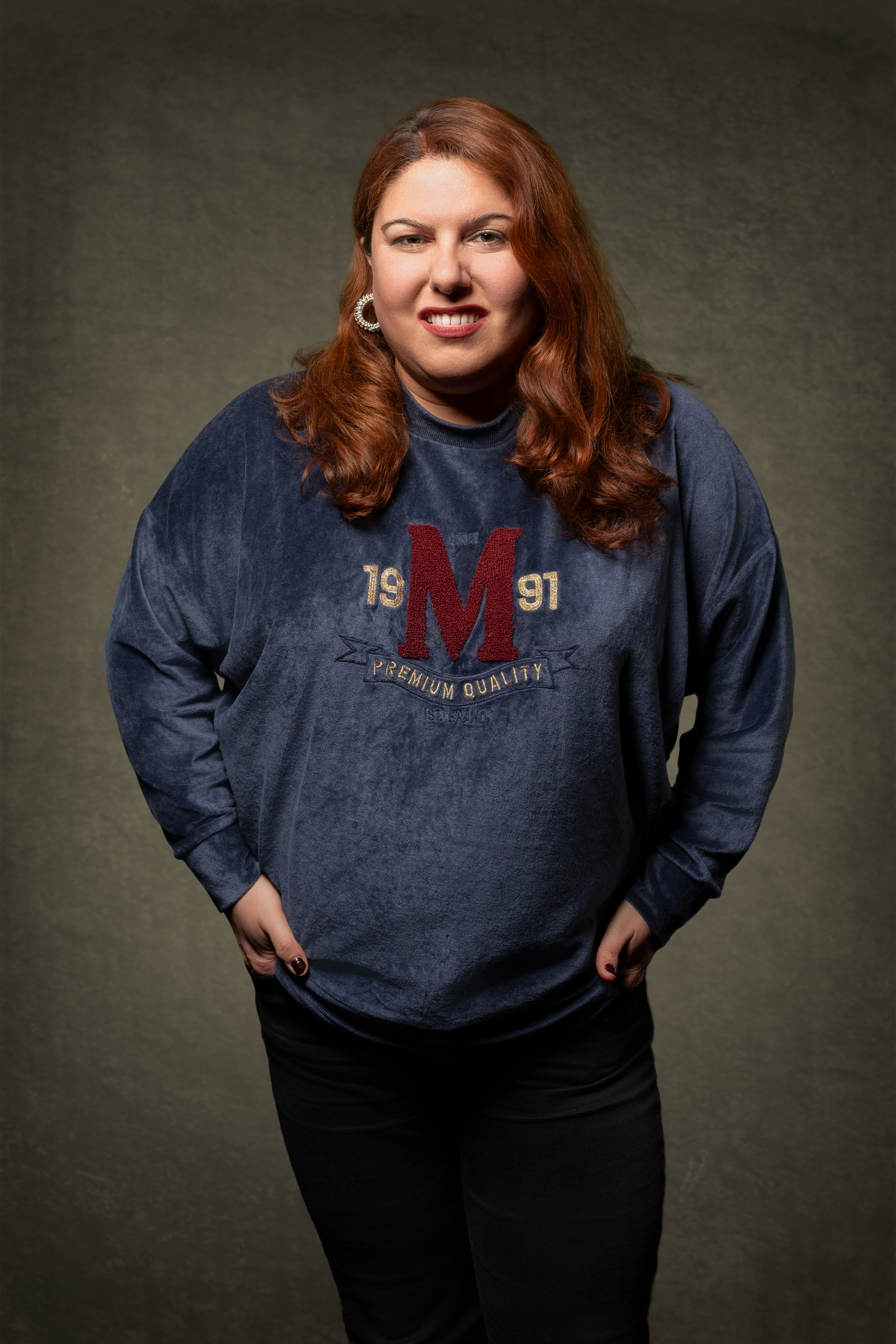 Frau in dunkelblauem Sweatshirt vor neutralem Hintergrund.