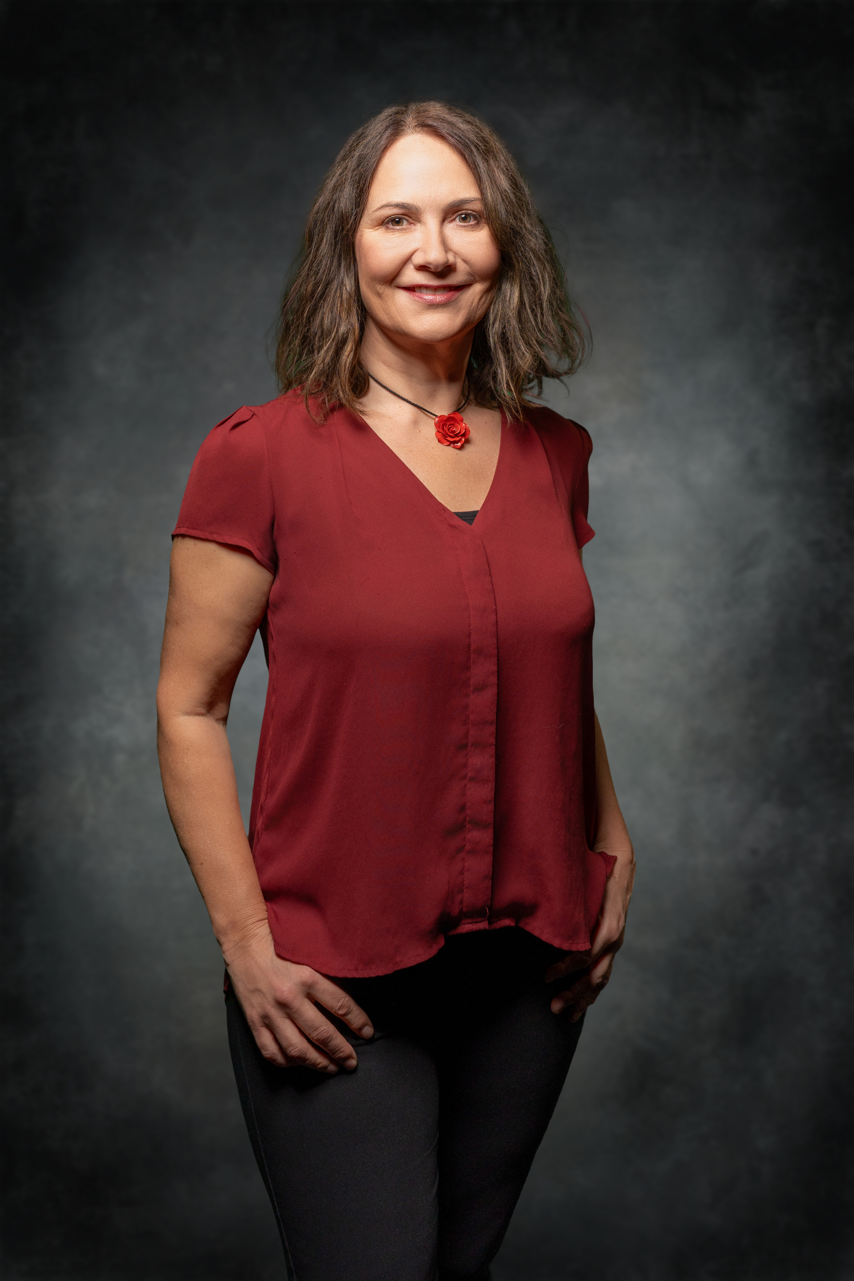 Damenbluse in Rot, getragen von einer Frau mit lässigem Outfit und freundlichem Lächeln.