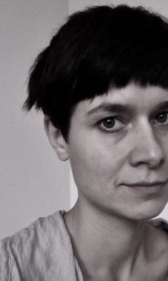 Schwarz-weiß Selbstporträt einer Frau mit kurzem Haar und ernstem Ausdruck.